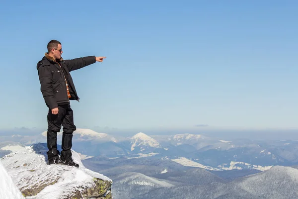Silhouet van alleen toerist staan op besneeuwde bergtop genieten — Stockfoto