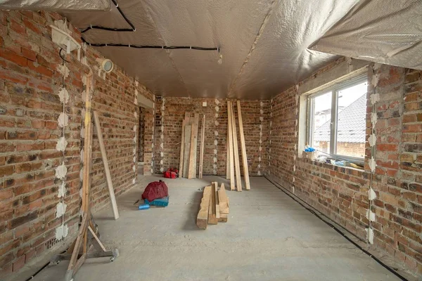 Interior da casa de tijolo inacabado com piso de concreto e nu — Fotografia de Stock