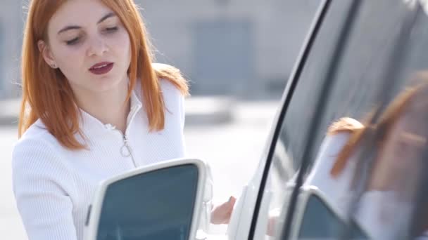 マイクロファイバークロスで洗浄した後 若い女性は彼女の新しい車を掃除します — ストック動画