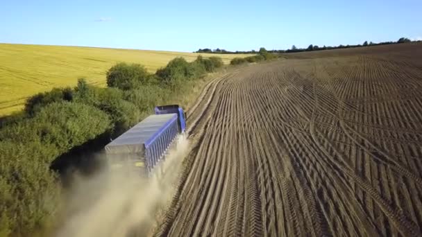 从空中看一辆卡车在犁地之间的土路上行驶 产生了大量灰尘 — 图库视频影像