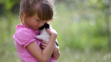 Güzel bir kız çocuğu yazın dışarıda köpek yavrusuyla oynuyor..