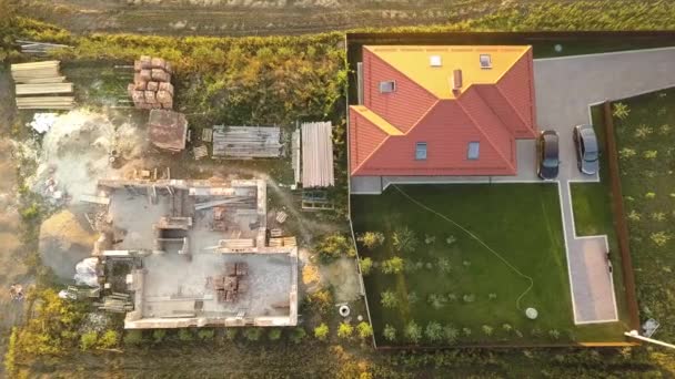 从上往下俯瞰两座私有房屋 一座是正在建造的带木制屋架的房屋 另一座是用红色砖瓦屋顶建成的房屋 — 图库视频影像