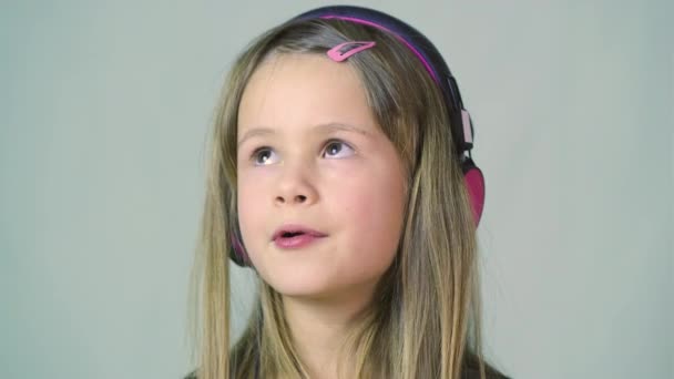 Bastante Chica Cild Sonriente Escuchando Música Grandes Auriculares Rosados — Vídeos de Stock