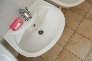 Parlak paslanmaz çelik suyu olan beyaz seramik yıkama leğenleri.