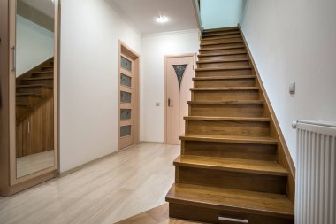 Bir evin ya da meşe ağacından merdivenleri olan bir apartman koridoru.