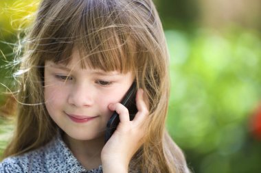 Sevimli çocuk genç kız cep telefonu açık havada konuşuyor. Çocuklar bir