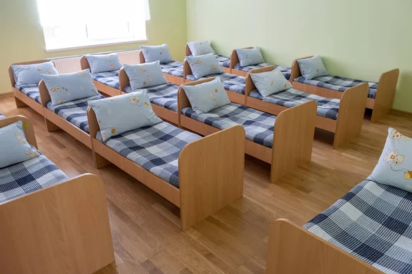 Багато маленьких ліжок зі свіжою білизною в дошкільному дошкільному закладі порожнє ліжко — стокове фото