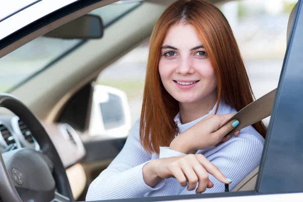 Visão de ângulo largo da jovem mulher ruiva motorista preso pelo assento — Fotografia de Stock