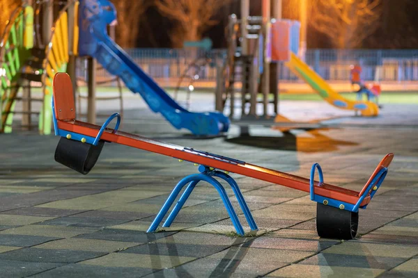 Seesaw swing in preschool yard with soft rubber flooring at nigh — Stock Photo, Image