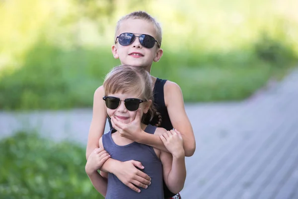Dos niños en gafas de sol negras divirtiéndose al aire libre en suma — Foto de Stock