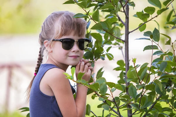 Ung söt barn flicka i fashionabla solglasögon kramar grön — Stockfoto