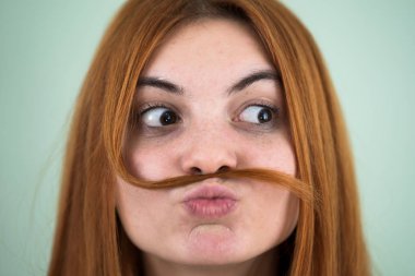 Mus gibi uzun kızıl saçlı komik bir kızın yakın portresi.