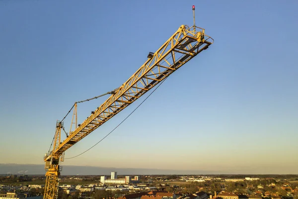 Tower crane on bright blue sky copy space background, city landscape stretching to horizon. Drone aerial photography. — Stock Photo, Image