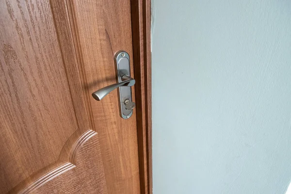 Fechar-se de uma maçaneta de porta metálica em portas de madeira . — Fotografia de Stock