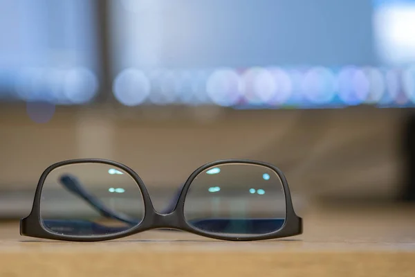 Primer plano de gafas protectoras en un escritorio vacío con borrador borroso —  Fotos de Stock