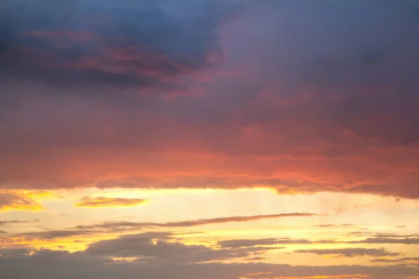 Закатное небо окутано оранжевыми пушистыми облаками. — стоковое фото