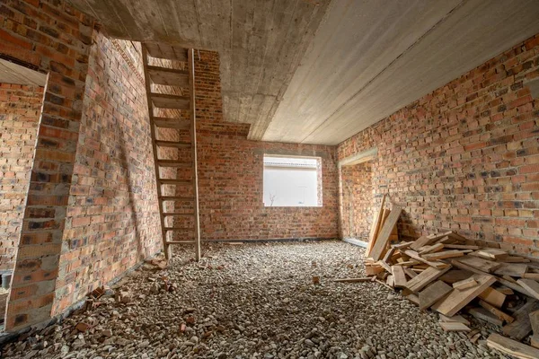 Interior de la casa de ladrillo sin terminar con piso de hormigón y desnudo — Foto de Stock