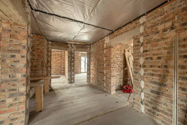 Interior da casa de tijolo inacabado com piso de concreto e nu — Fotografia de Stock