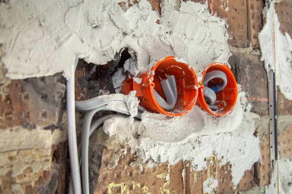 Socket orange boxes with wires in a wall. Cabling installation o — Stock Photo, Image
