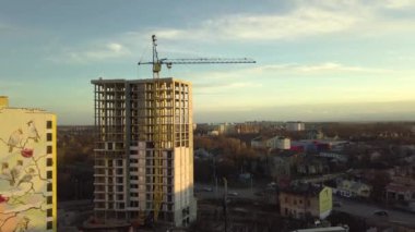 Bir şehirde inşaat halindeki tamamlanmamış uzun apartmanın beton çerçevesinin havadan görüntüsü..