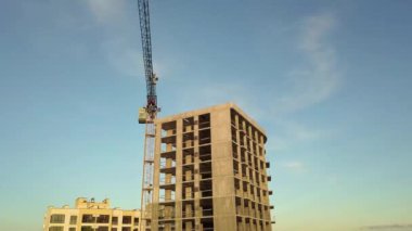 Bir şehirde inşaat halindeki tamamlanmamış uzun apartmanın beton çerçevesinin havadan görüntüsü..