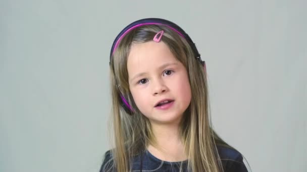 Bastante Chica Cild Sonriente Escuchando Música Grandes Auriculares Rosados — Vídeo de stock