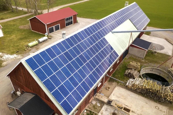 Tampilan teratas panel voltaik foto surya biru pada bangunan kayu, gudang atau atap rumah. Konsep produksi energi hijau ekologi terbarukan. — Stok Foto