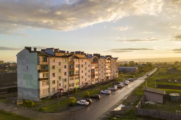 Paisaje suburbio, edificio de apartamentos. Coches aparcados a lo largo de mala carretera — Foto de Stock