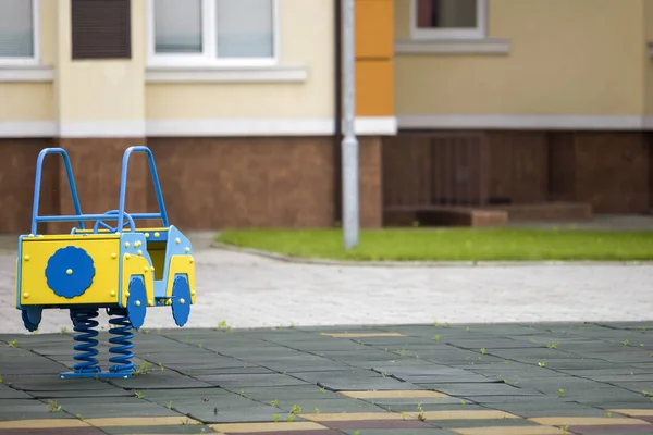 Dagis lekplats med ljus leksaksbil på våren. Barnaktiviteter och rekreation utomhus. — Stockfoto