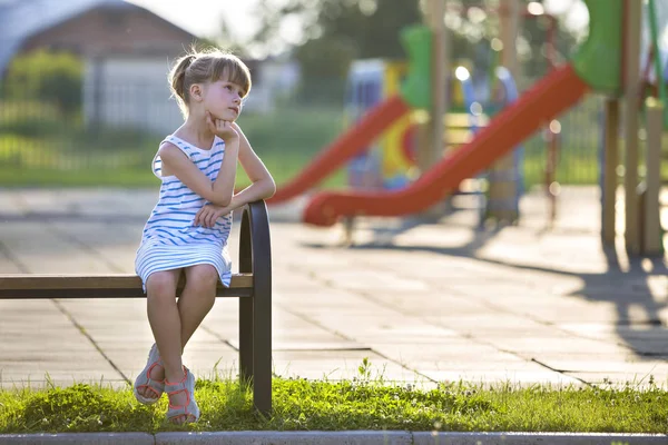Kısa elbiseli sevimli genç kız playgro açık havada yalnız oturuyor — Stok fotoğraf