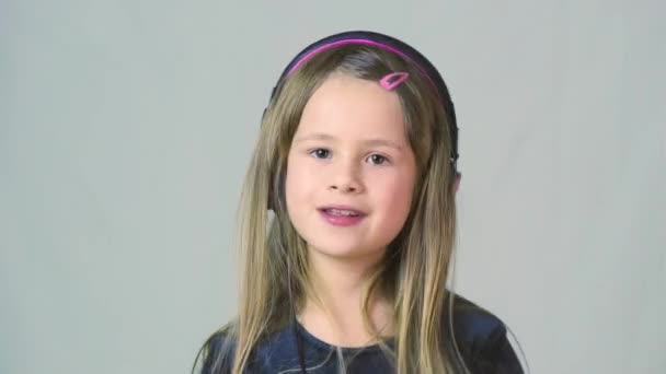 Bastante Chica Cild Sonriente Escuchando Música Grandes Auriculares Rosados — Vídeos de Stock