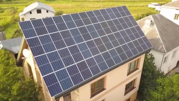 屋根の上に青色の光沢のある太陽光発電パネルシステムと新しい近代的な住宅のコテージの空中トップビュー 再生可能エネルギーグリーンエネルギー生産コンセプト — ストック動画
