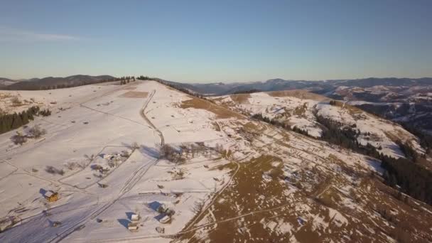 Vista Aérea Pequena Aldeia Com Casas Espalhadas Colinas Cobertas Neve — Vídeo de Stock