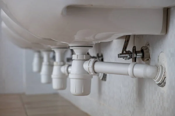 Close-up de tubo de plástico branco drenar sob pia de lavagem em bathr — Fotografia de Stock