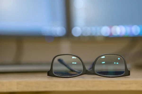 Primer plano de gafas protectoras en un escritorio vacío con borrador borroso —  Fotos de Stock