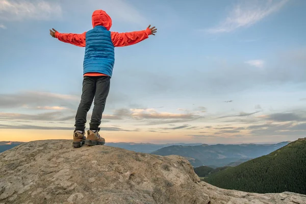 Niño pequeño excursionista de pie con las manos levantadas en las montañas en — Foto de Stock