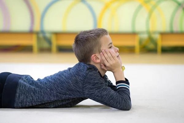 Giovane bambino ragazzo sdraiato e relaxiong mentre si riposa sul f — Foto Stock