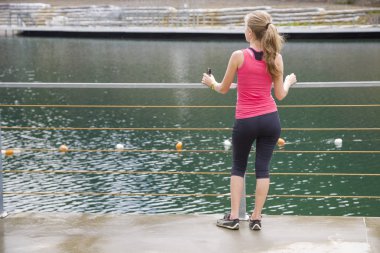 Spor elbiseli genç bir kadının ayakta duruşu. 