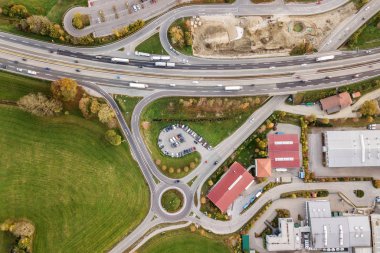 Çevre yolu boyunca ilerleyen trafikli otobanın yukarıdan aşağı hava görüntüsü