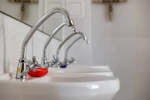 Lavabi in ceramica bianca con acqua lucida in acciaio inox ta — Foto Stock