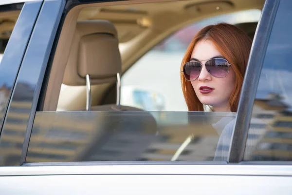 Mujer joven con pelo rojo y gafas de sol viajando en coche. Pas — Foto de Stock