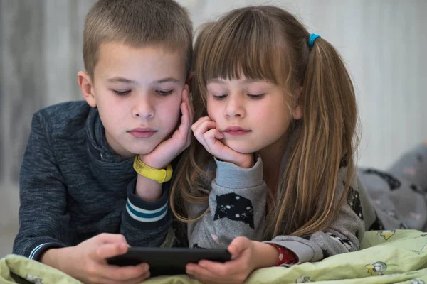 Dos niños hermano y hermana viendo vídeo en el teléfono inteligente scr — Foto de Stock