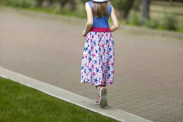 उन्हाळ्यात ड्रेसमध्ये लहान मुलगी आणि हॅट ग्रीमध्ये एकटा चालत आहे — स्टॉक फोटो, इमेज