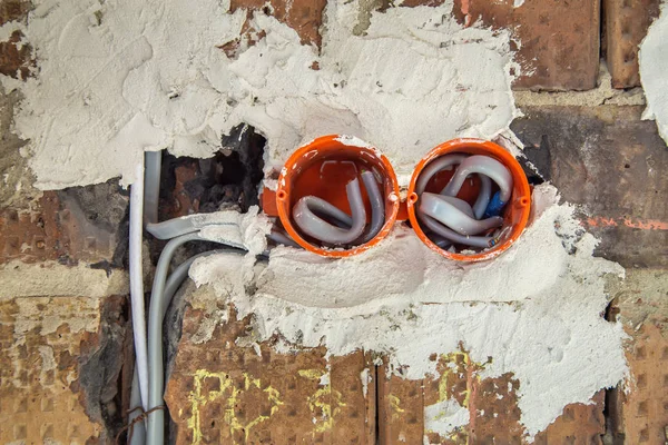 Socket oranje dozen met draden in een muur. Kabelinstallatie o — Stockfoto