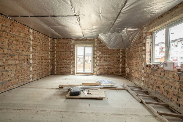 Interior da casa de tijolo inacabado com piso de concreto e nu — Fotografia de Stock