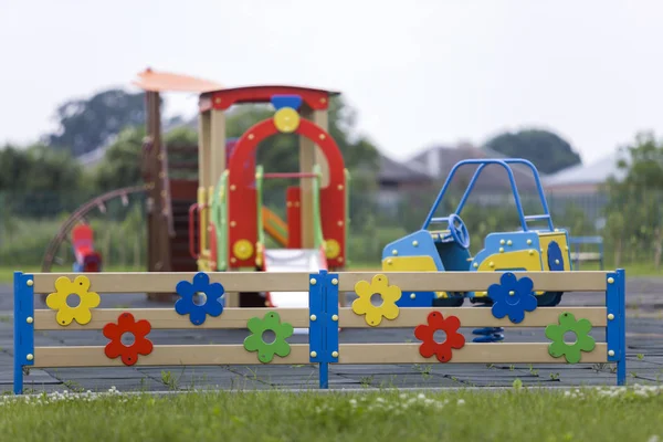 Nursery playground with bright toy car and colorful fence. Children activities and recreation outdoors. — 스톡 사진