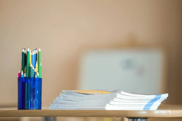 Wooden colorful drawing pencils arranged in plastic jug and stac — Stock Image Wooden colorful drawing pencils arranged in plastic jug and stac Stock Photo