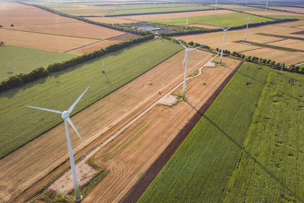 Aerial view of wind turbine generators in field producing clean 