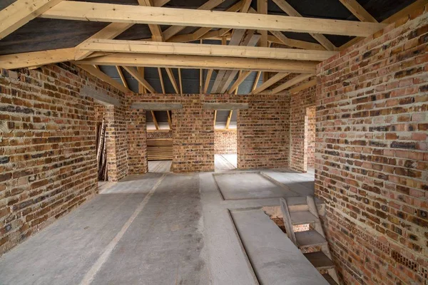 Interiör av ofullbordat tegelhus med betonggolv, öppen planlösning — Stockfoto