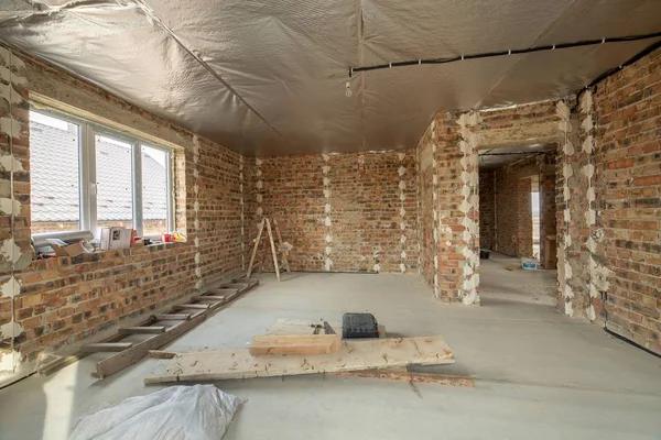 Интерьер незавершенного кирпичного дома с бетонным полом и голым — стоковое фото